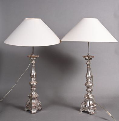 pair of silver metal table lamps with white shades on a grey background