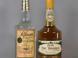 two bottles of rum and a bottle of liquor on a table