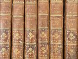 a close up of a row of old books on a shelf