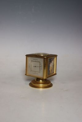 a small clock sitting on top of a gold stand