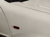 a close up of a white car with a red door handle