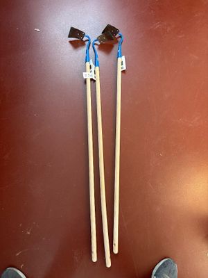 two pairs of chopsticks on the floor next to a pair of shoes