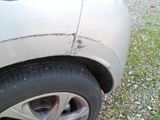 a close up of a car ' s tire on a gravel road