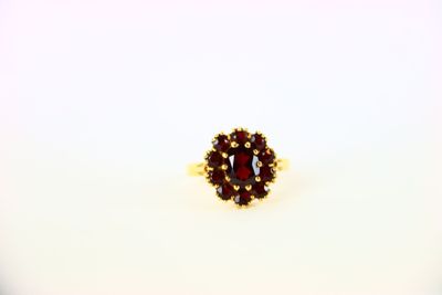 a close up of a ring with a red stone in it