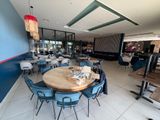 des tables et des chaises dans un restaurant aux murs bleus et au sol carrelé de blanc