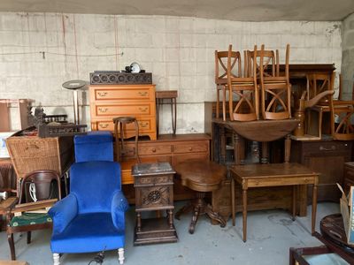 une pièce avec beaucoup de meubles et un fauteuil bleu