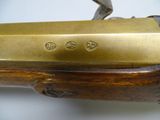 a close up of a brass plated rifle with a wooden handle