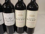 four bottles of red wine are lined up on a counter