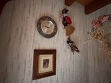 une photo d'un mur sur lequel sont accrochés une horloge et des tableaux
