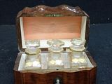 a small wooden box that has a bunch of glass items inside of it