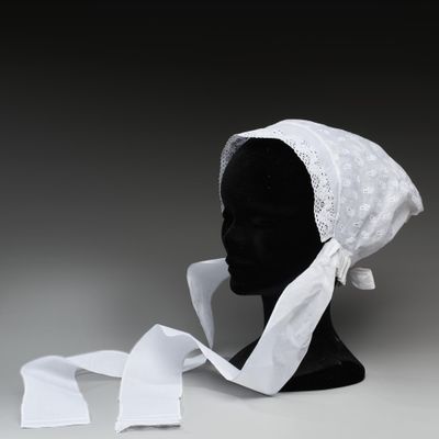 une tête de mannequin noire coiffée d'un bonnet blanc