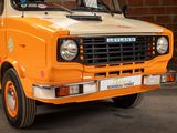 an orange truck parked in front of a brick wall