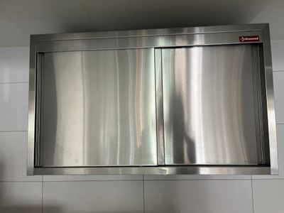 une armoire en acier inoxydable au milieu d'un mur carrelé