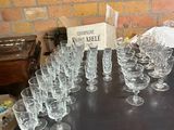 Des bouteilles et des verres sont alignés sur une table devant un mur de briques.
