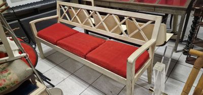 un banc blanc avec des coussins rouges dans une pièce