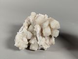 crystal cluster on a white surface with a gray background