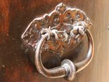 a close up of a metal door handle on a wooden door