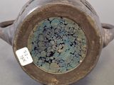 a close up of a vase with a tag on it
