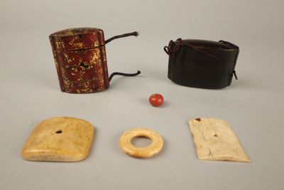 trois morceaux de bois et un étui en cuir posés sur une table