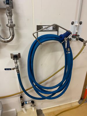 un tuyau bleu fixé au mur à côté d'un évier