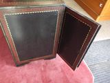 pair of antique black and brown leather cabinet doors with brass hardware