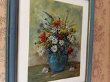 a painting of flowers in a blue vase hanging on a wall
