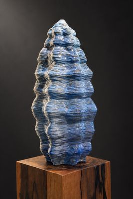 un gros plan sur une sculpture représentant un rocher posé sur un bloc de bois