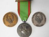 three medals and a medal on a white surface
