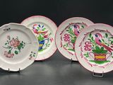 trois assiettes ornées de motifs roses et verts sur un fond noir