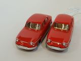 two red toy cars sitting next to each other on a table