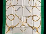 a green and white scarf with gold scissors and chains on it