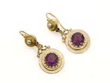 une photo d'une paire de boucles d'oreilles ornées de pierres violettes