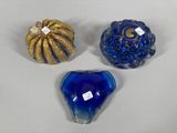 three blue glass vases sitting next to each other on a white surface
