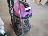 un aspirateur rose posé par terre