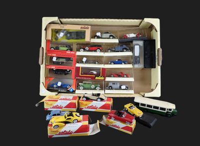 de nombreuses petites voitures et camions dans une boîte posée sur une table
