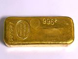 gros plan d'un lingot d'or sur une surface blanche