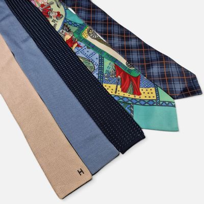 four different colored ties with different designs on them on a white surface