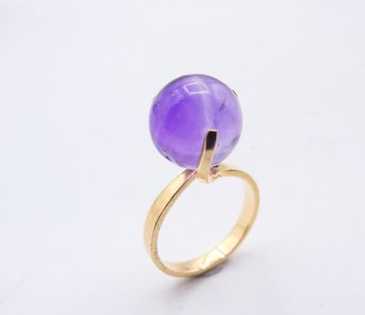 a close up of a ring with a purple stone on it