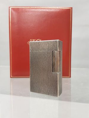 an image of a silver lighter sitting next to a red box