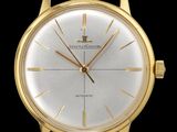 une image montrant un gros plan d'une montre en or sur fond noir