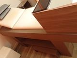 a desk with a laptop on top of it in a room