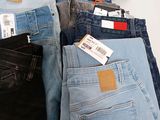 several pairs of men ' s jeans are lined up on a table