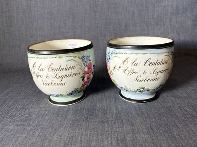 deux petites tasses portant une inscription, posées sur une surface grise