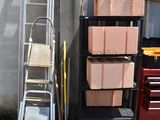 a stack of boxes and a ladder in front of a building