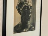 a picture of a bust of a woman hanging on a wall