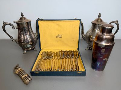 a box of silverware sitting on a table next to a teapot
