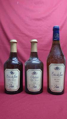 three bottles of wine are lined up against a pink backdrop