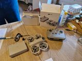 une table sur laquelle se trouvent une boîte, une télécommande et d'autres objets