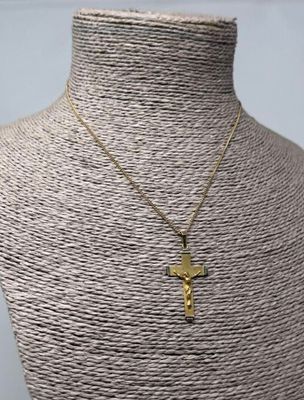 un collier avec une croix en or sur un mannequin, un mannequin, un mannequin, un mannequin, un mannequin, un mannequin, un mannequin, un mannequin, un manne
