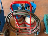 a picture of a cart with a hose and a bucket on it